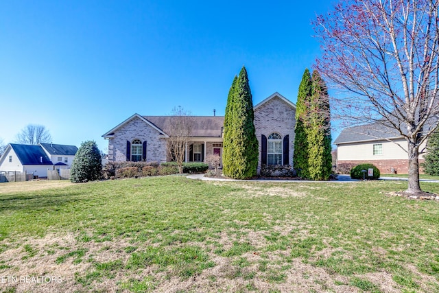 view of front of house with a front yard and brick siding