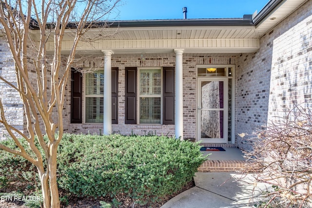 view of exterior entry with brick siding