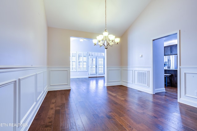 unfurnished dining area featuring visible vents, lofted ceiling, dark wood finished floors, and a decorative wall