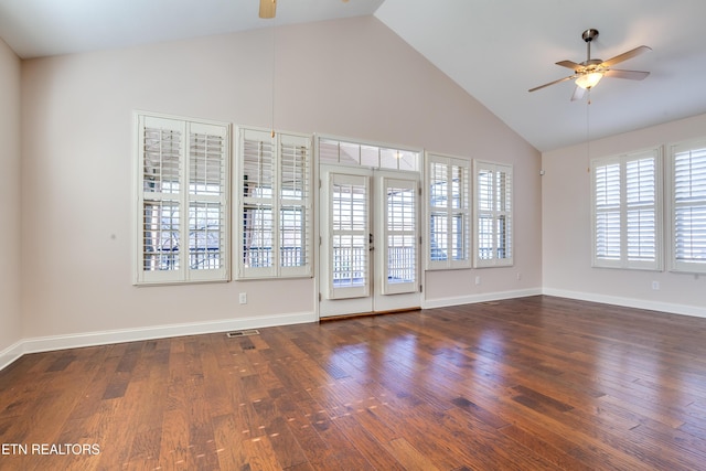 empty room with visible vents, high vaulted ceiling, a ceiling fan, wood finished floors, and baseboards