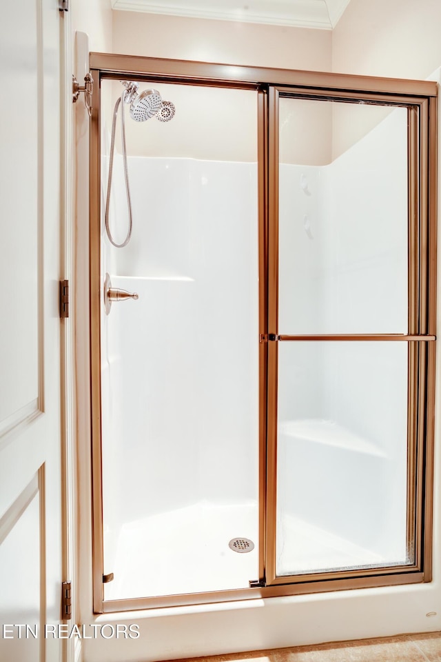 full bathroom with a stall shower and crown molding