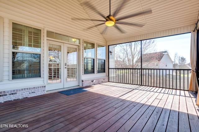 unfurnished sunroom with ceiling fan and vaulted ceiling