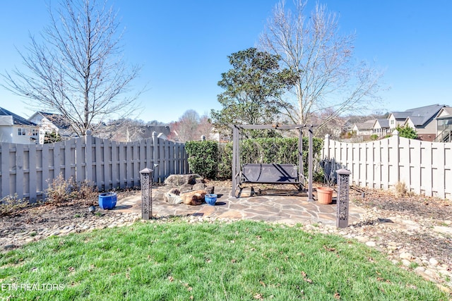 view of yard featuring a patio area, a fenced backyard, and a residential view