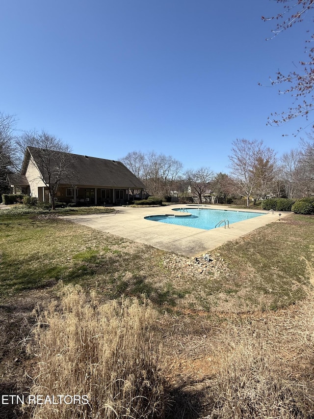 community pool with a yard and a patio area