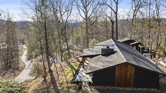 drone / aerial view featuring a wooded view