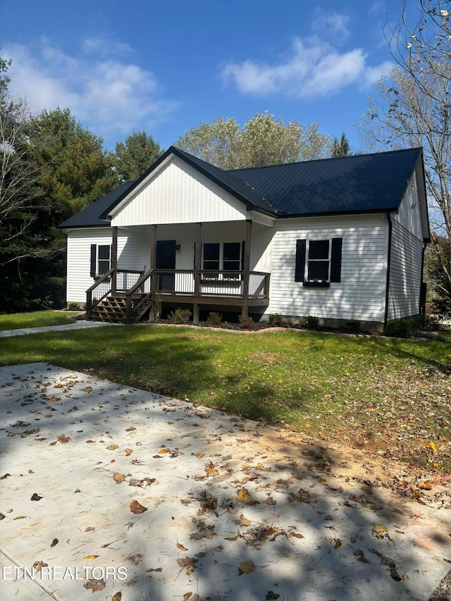 view of front of property featuring a porch, metal roof, and a front lawn