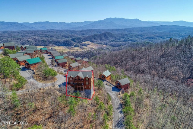 aerial view featuring a wooded view and a mountain view