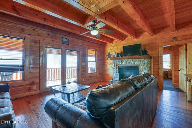 living room featuring wooden ceiling, hardwood / wood-style flooring, a ceiling fan, and wood walls