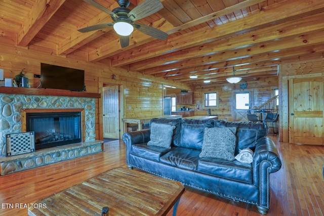 living area with wooden walls, wood ceiling, a ceiling fan, and hardwood / wood-style flooring