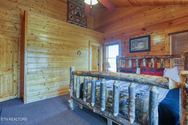 bedroom featuring wooden walls, lofted ceiling with beams, and carpet floors