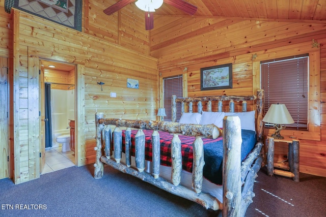 tiled bedroom featuring wooden walls, wood ceiling, high vaulted ceiling, carpet flooring, and ensuite bath