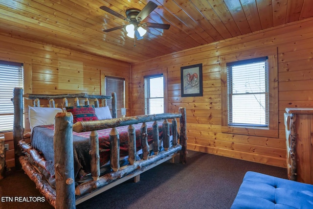 carpeted bedroom with wood ceiling and wood walls