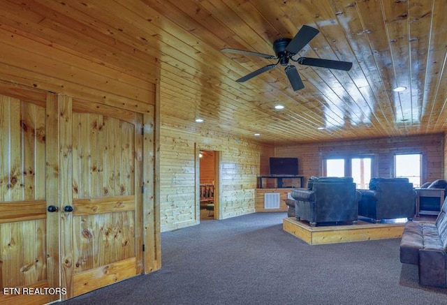 living room with wooden walls, carpet, visible vents, ceiling fan, and wood ceiling