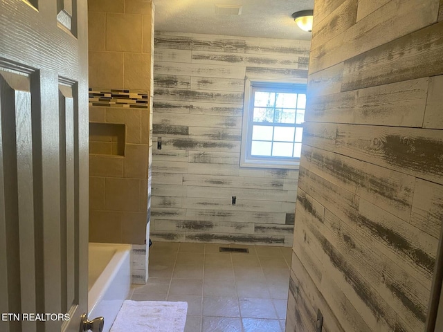 bathroom featuring tile patterned floors, a bathing tub, walk in shower, and wooden walls