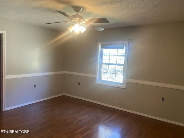 unfurnished room featuring a ceiling fan, dark wood-style floors, baseboards, and a textured ceiling