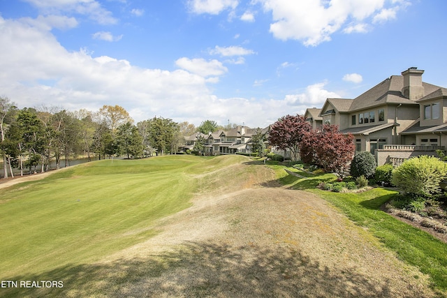 surrounding community with golf course view, a residential view, and a lawn