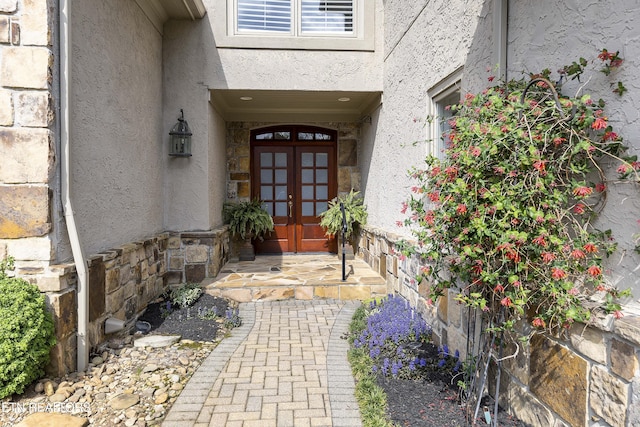 property entrance featuring french doors and stucco siding
