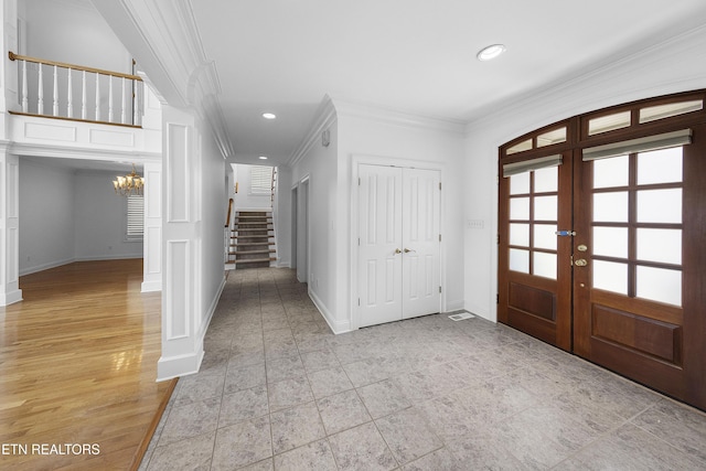 foyer with a notable chandelier, crown molding, stairway, recessed lighting, and french doors