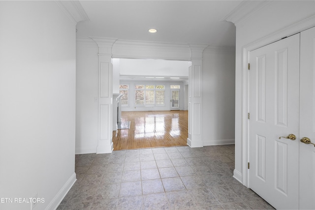 hall with baseboards, tile patterned flooring, ornate columns, and crown molding