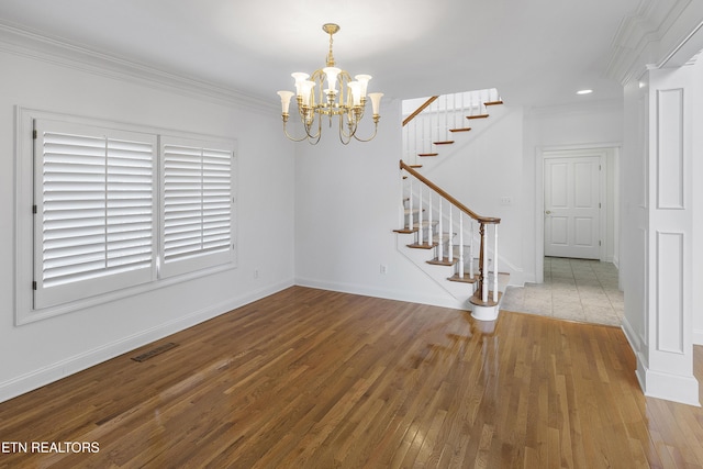unfurnished dining area featuring stairway, visible vents, hardwood / wood-style flooring, and an inviting chandelier