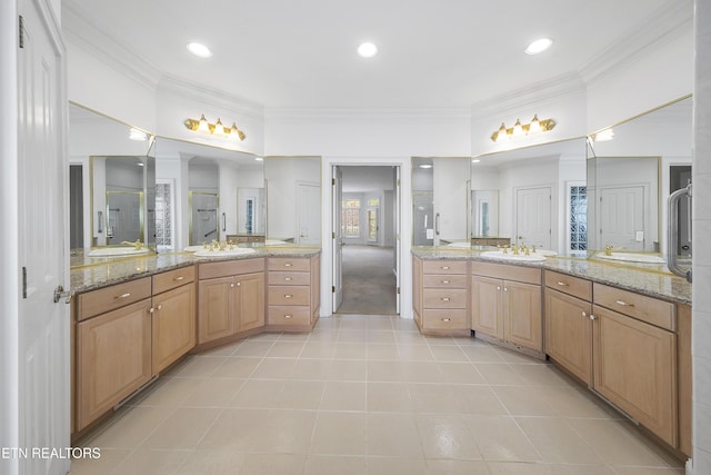 bathroom featuring a shower stall, tile patterned flooring, a sink, and ornamental molding
