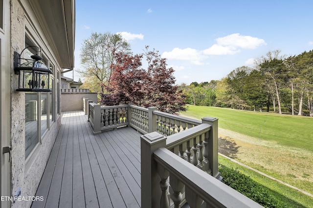 wooden deck featuring a lawn
