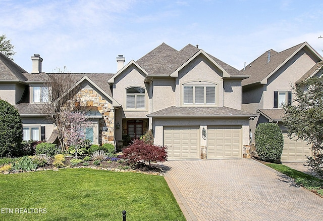 view of front of house featuring a front yard, stone siding, stucco siding, and decorative driveway