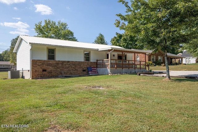 ranch-style home featuring brick siding, central AC unit, metal roof, and a front lawn