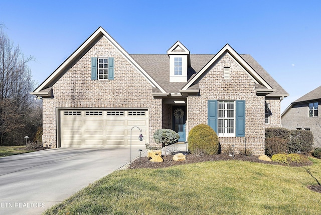 view of front of home with driveway, roof with shingles, a front lawn, a garage, and brick siding