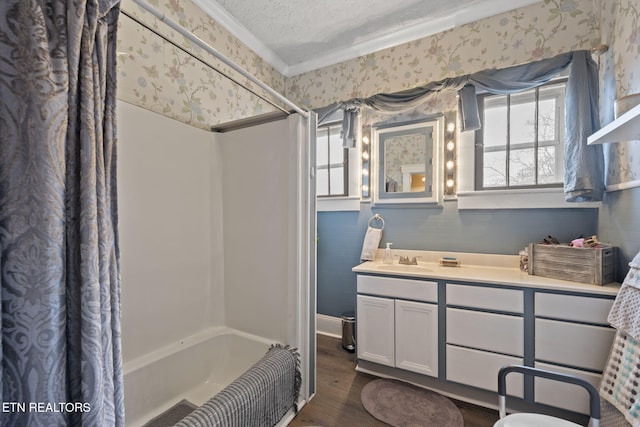 bathroom with wallpapered walls, shower / bath combo with shower curtain, vanity, wood finished floors, and a textured ceiling