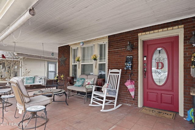 entrance to property with brick siding and covered porch