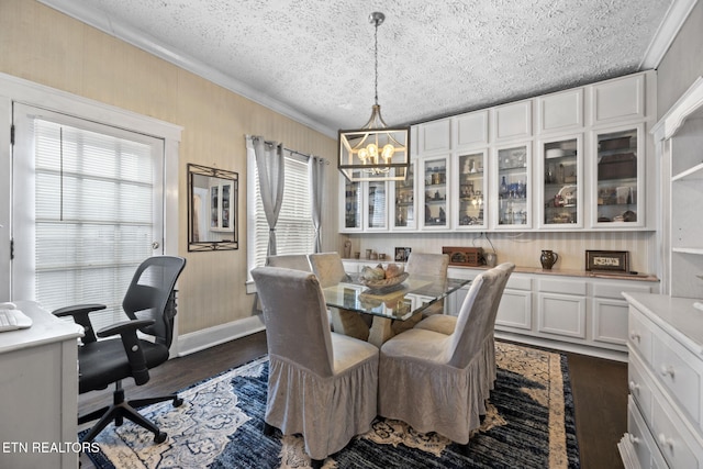 dining space featuring a wealth of natural light, a textured ceiling, dark wood finished floors, and crown molding