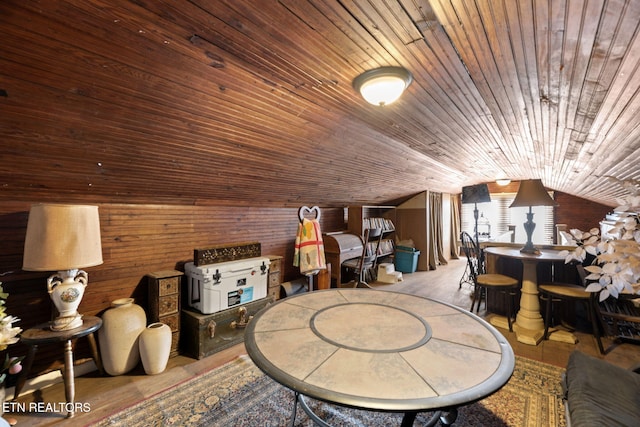 additional living space with lofted ceiling, wood walls, and wooden ceiling