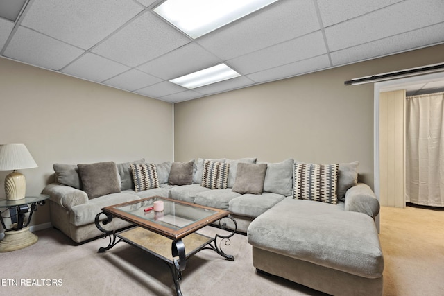 living room with a paneled ceiling and carpet floors