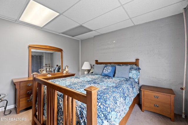 bedroom with light carpet and a drop ceiling