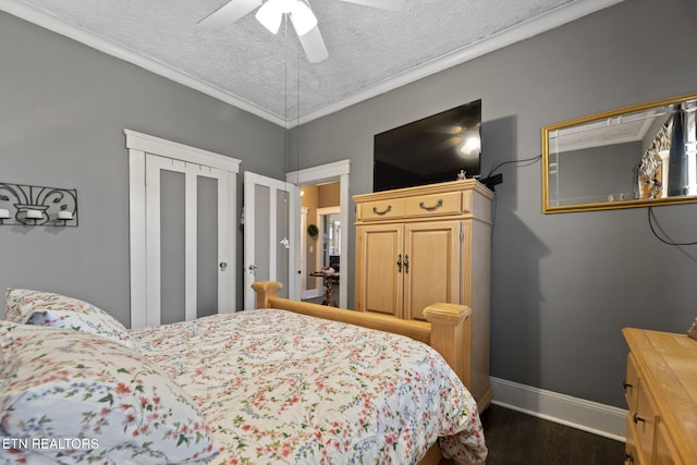 bedroom featuring a ceiling fan, baseboards, dark wood finished floors, ornamental molding, and a textured ceiling