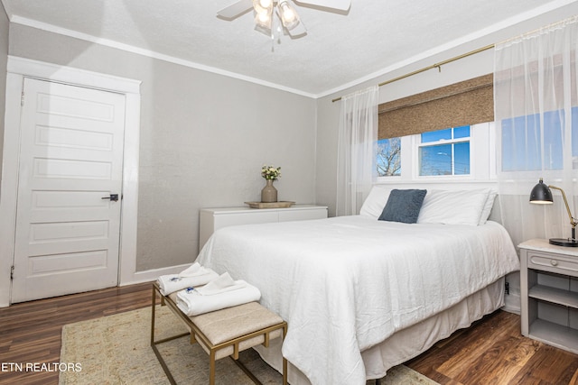 bedroom with ceiling fan, crown molding, dark wood-style flooring, and a textured ceiling