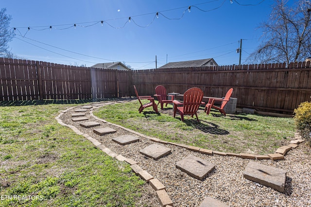 view of yard with a fenced backyard and an outdoor fire pit