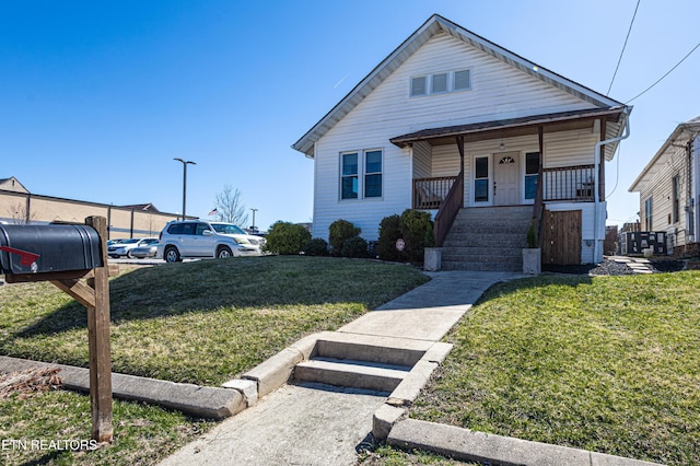 bungalow-style home with covered porch and a front yard