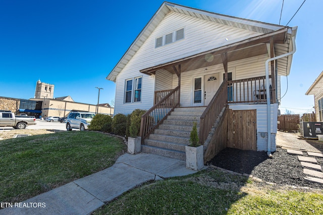 view of front facade with a porch, cooling unit, and a front lawn