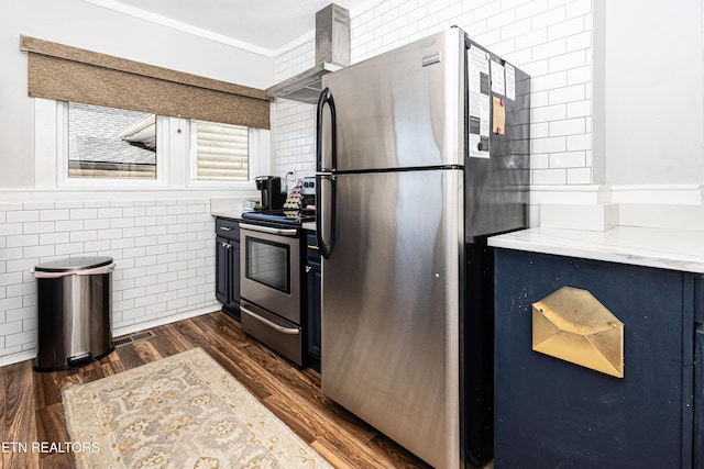 kitchen with visible vents, tile walls, wall chimney range hood, stainless steel appliances, and dark wood-style flooring