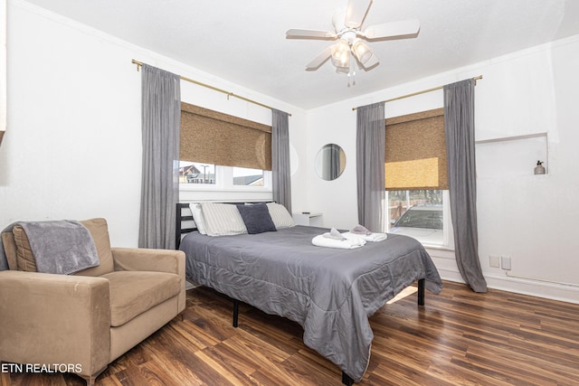 bedroom featuring baseboards, wood finished floors, a ceiling fan, and crown molding