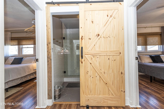 hall with a barn door and wood finished floors