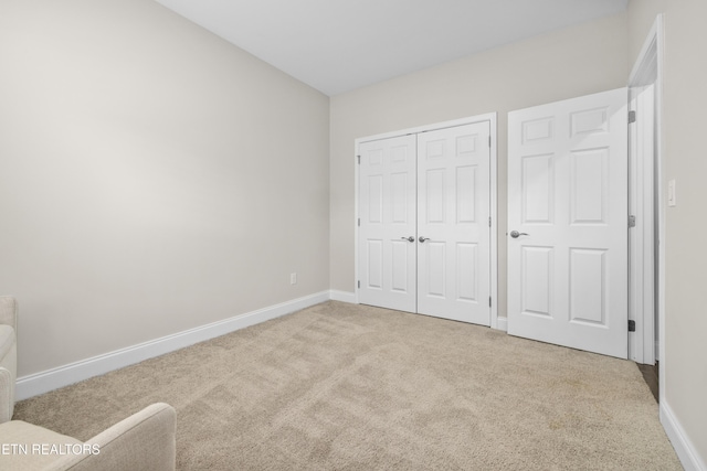 unfurnished bedroom featuring a closet, baseboards, and carpet