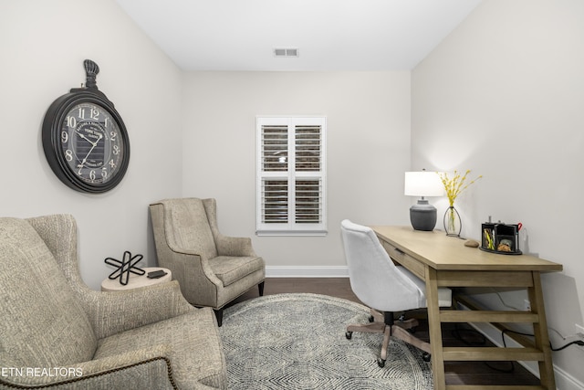 office area featuring visible vents, baseboards, and wood finished floors