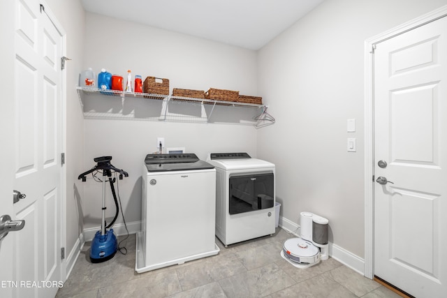 laundry area with laundry area, separate washer and dryer, and baseboards