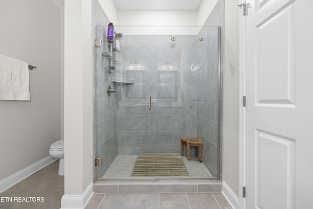 full bathroom featuring tile patterned floors, a stall shower, toilet, and baseboards