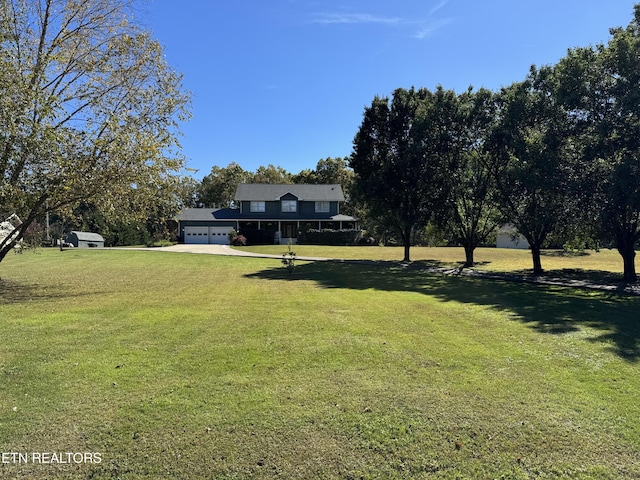 view of yard with an attached garage and driveway