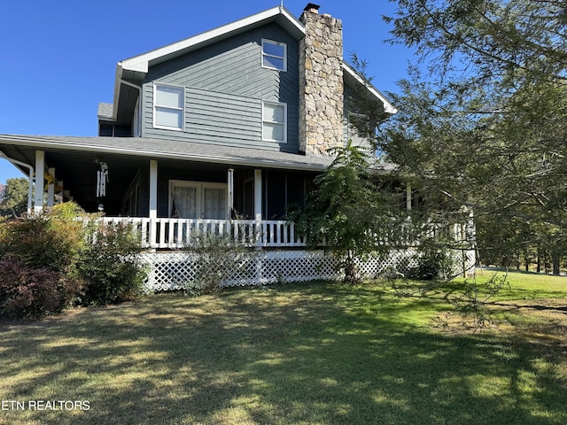 farmhouse with a front lawn, a porch, and a chimney