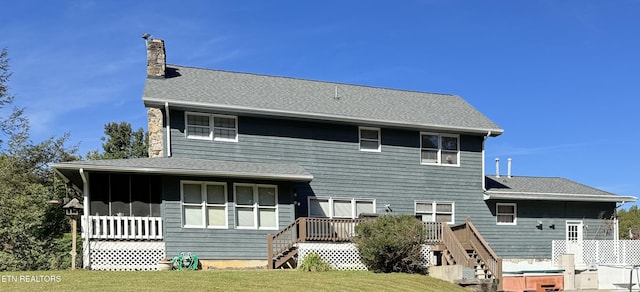 back of house featuring a deck, stairway, a sunroom, and a chimney